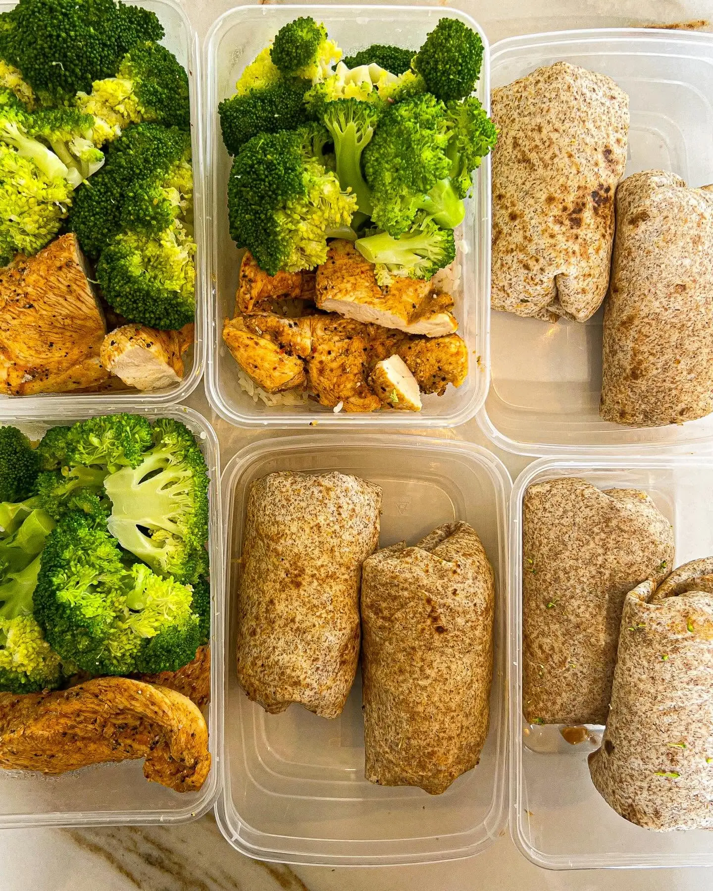Assorted prepared dishes with wraps, chicken and pasta