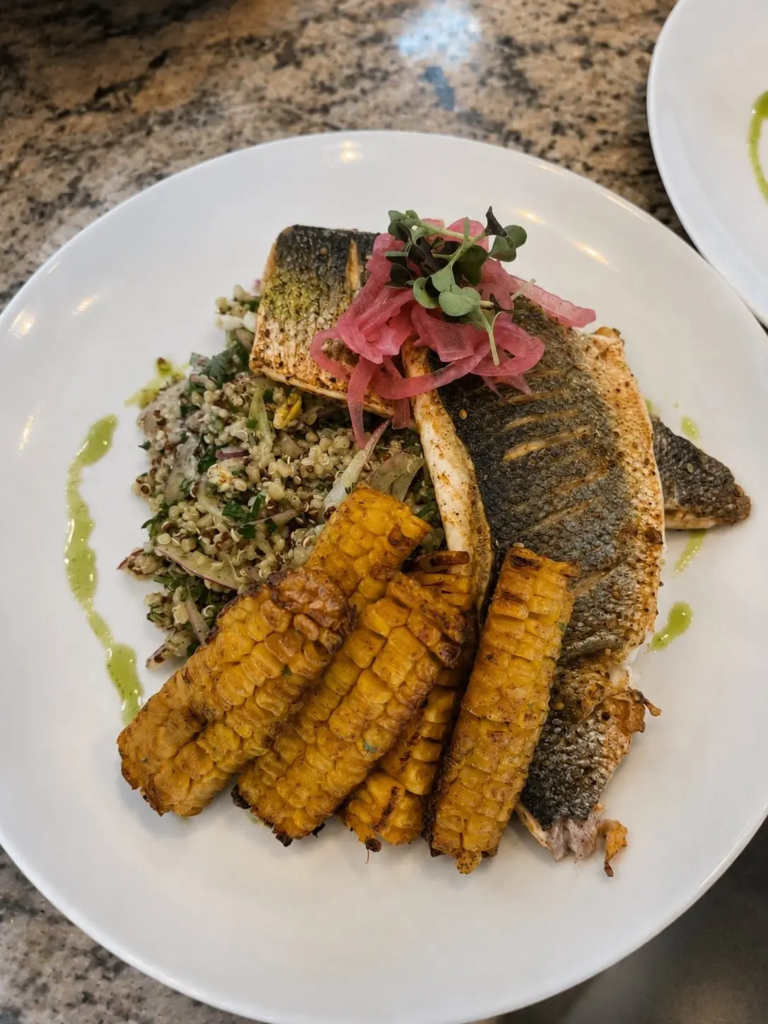 Sea bass with corn, grain salad and pickled onions